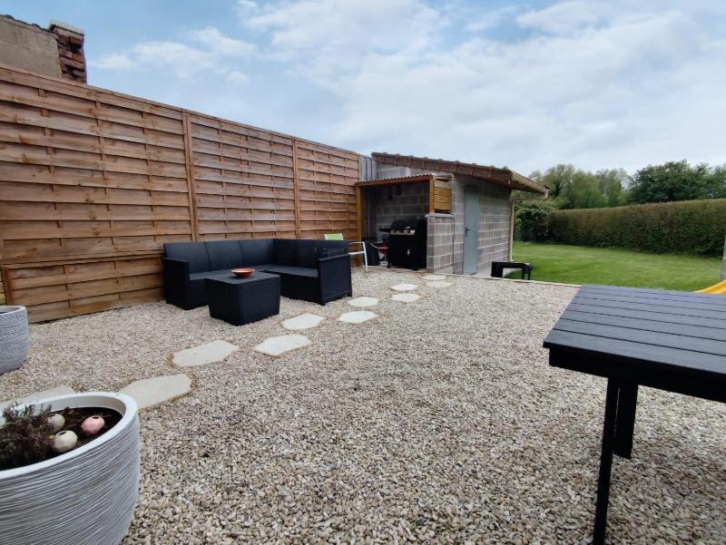 - un patio avec un canapé et une table dans l'établissement GÎTE PRIVATIF, MAISON DE VACANCES FAMILIALE 100m2 avec piscine, parking privé "Un plaisir d'évasion" gîte de France 3 épis, à Lillers