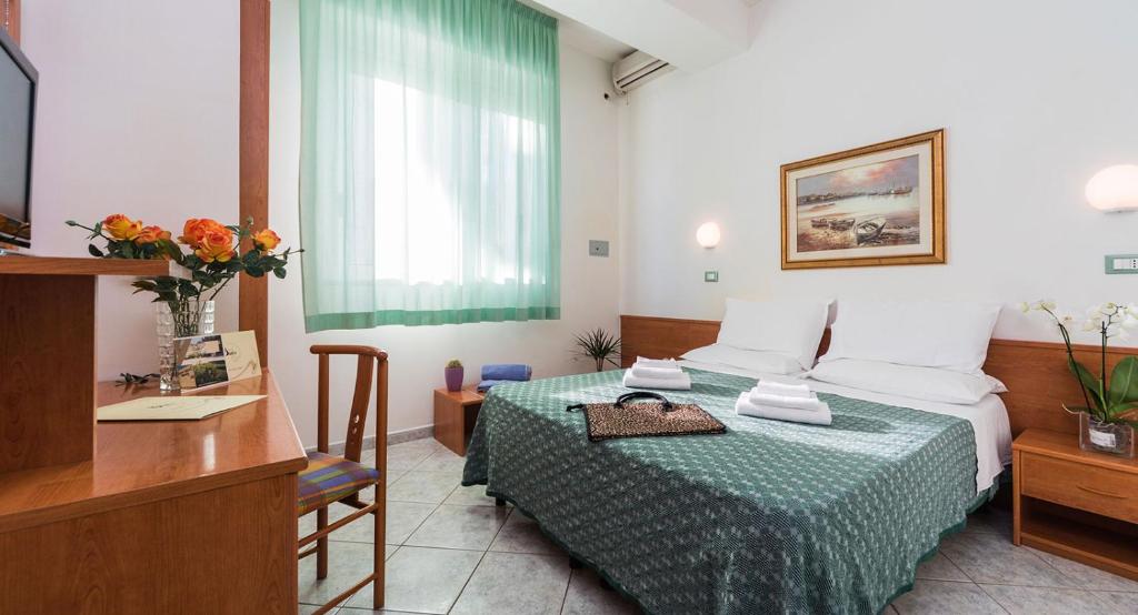 une chambre d'hôtel avec un lit, une table et un bureau dans l'établissement RESORT BAMBY, à Cervia