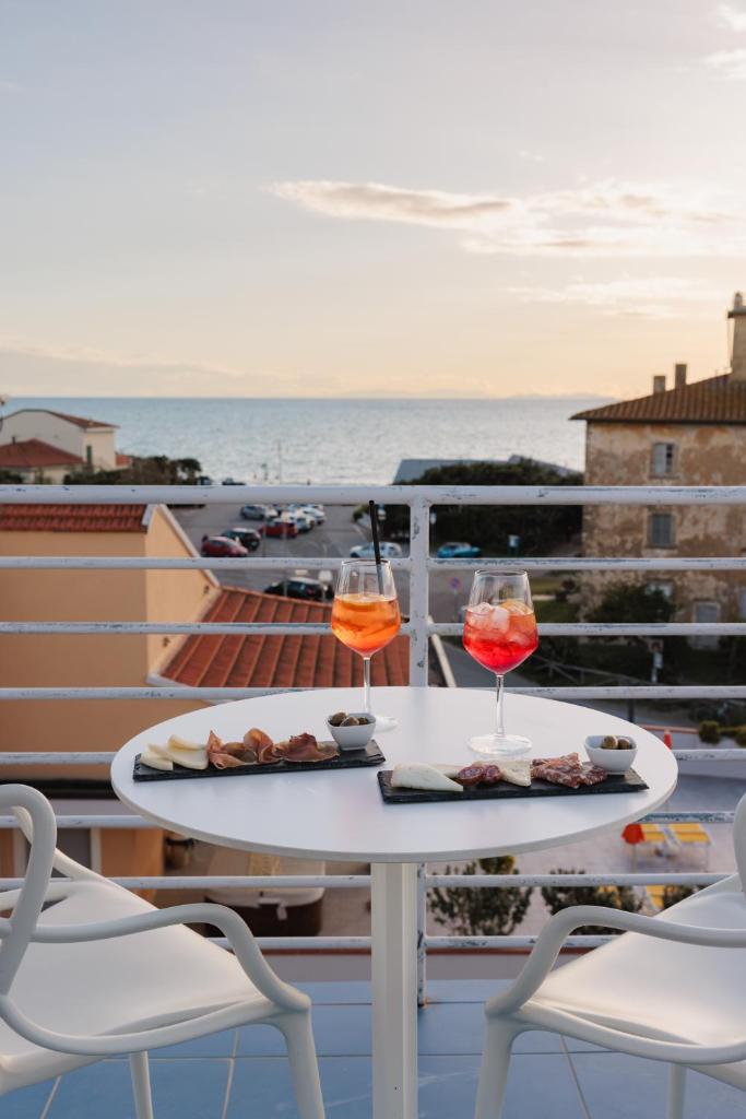- deux verres de vin assis sur une table sur un balcon dans l'établissement Hotel Nina, à Marina di Bibbona