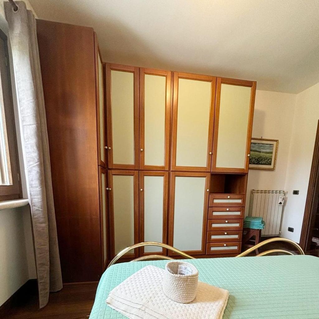 Cette chambre comprend une table et une grande armoire en bois. dans l'établissement Appartamento ai Ciliegi - tra Rignano Flaminio e Morlupo, à Magliano Romano