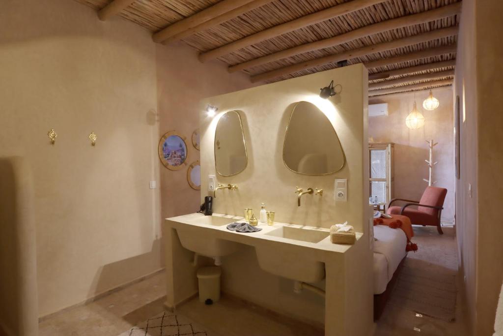 une salle de bain avec un lavabo et deux miroirs dans l'établissement Riad Darchica, à Marrakech