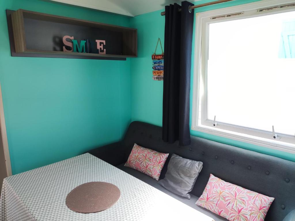 - une chambre avec un lit doté d'oreillers roses et d'une fenêtre dans l'établissement Europcamping Mobil-home Climatisé, à Fréjus