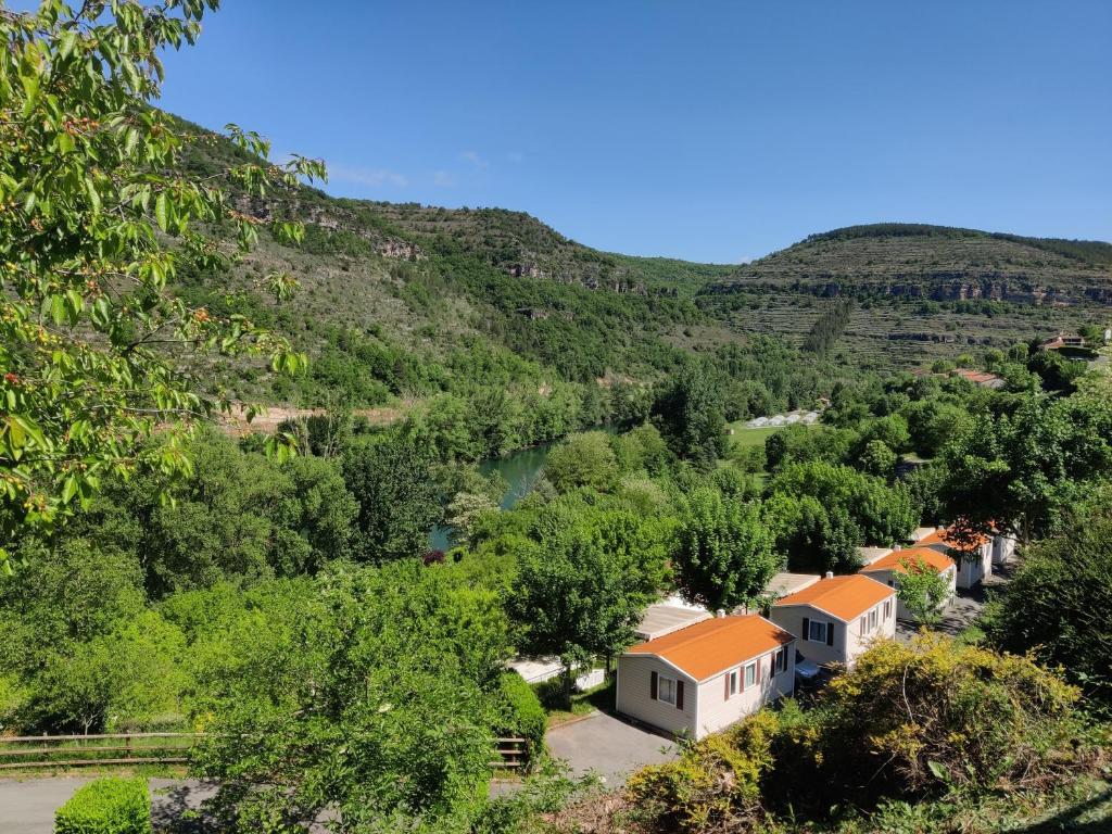 une vue sur une vallée avec des maisons et des arbres dans l'établissement Camping Cascade Aveyron, à Saint-Rome-de-Tarn