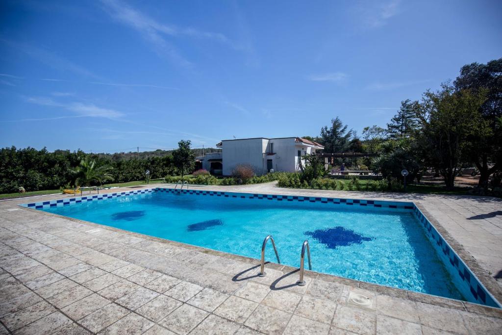 une piscine avec de l'eau bleue dans une cour dans l'établissement Casa Rizzini, à Giuggianello