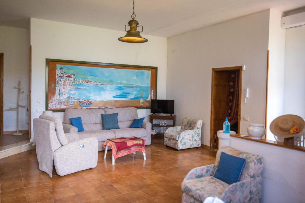 un salon avec un canapé et deux chaises dans l'établissement Casa Rizzini, à Giuggianello