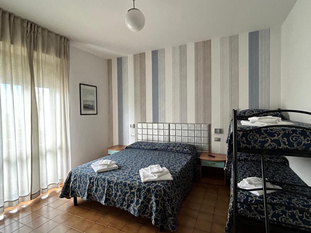 une chambre avec un lit et un lit superposé dans l'établissement Hotel Etna - Hotel per Coppie e Famiglie con Parcheggio e Spiaggia, à Riccione 55 autres photos