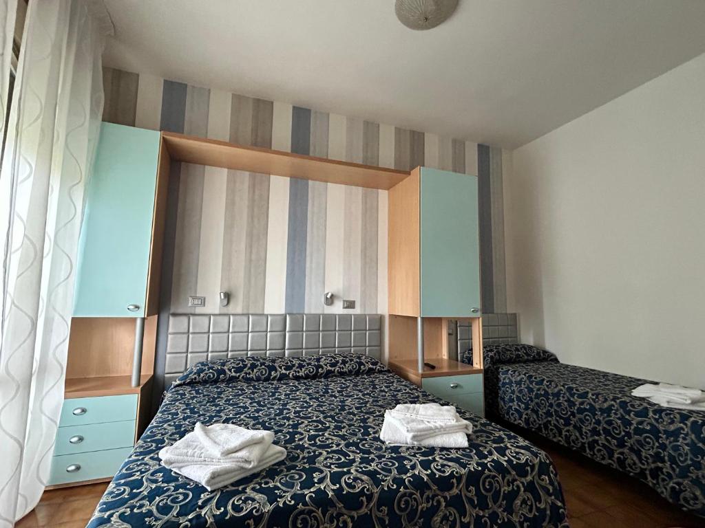 une chambre avec deux lits avec des serviettes dessus dans l'établissement Hotel Etna - Hotel per Coppie e Famiglie con Parcheggio e Spiaggia, à Riccione