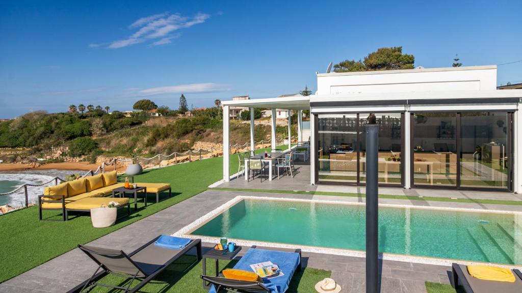 une maison avec une piscine et une terrasse dans l'établissement VILLA SABBIE ROSSE 6, Emma Villas, à Ovile la Marinella