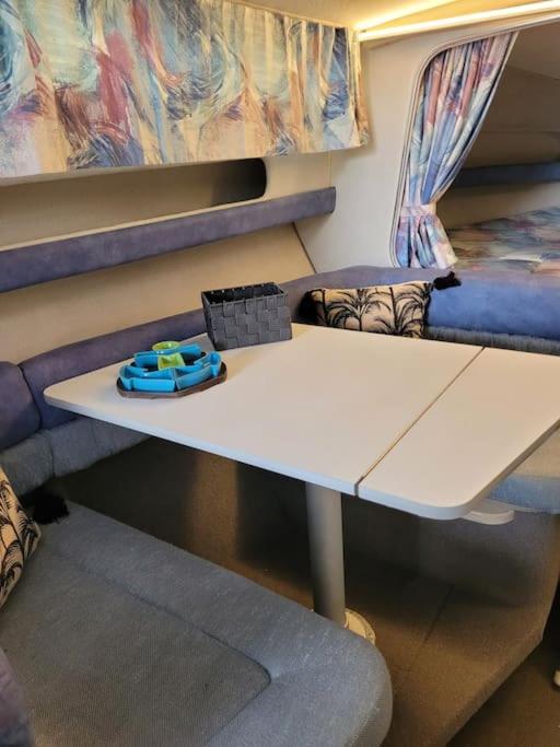 - une table blanche dans une chambre avec un lit dans l'établissement Bateau sur terre près du bassin, à Capvern