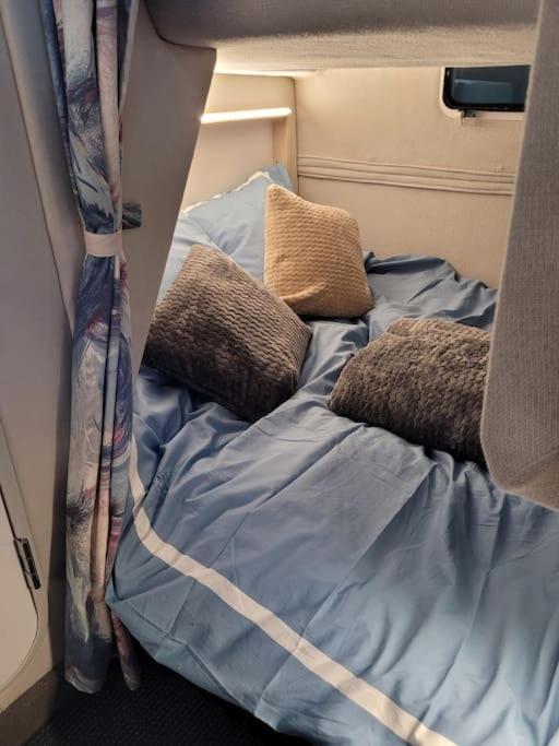 un lit avec des oreillers dessus dans une chambre dans l'établissement Bateau sur terre près du bassin, à Capvern