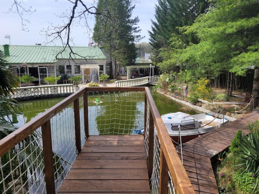 une maison avec un pont sur une rivière avec un bateau dans l'établissement Bateau sur terre près du bassin, à Capvern