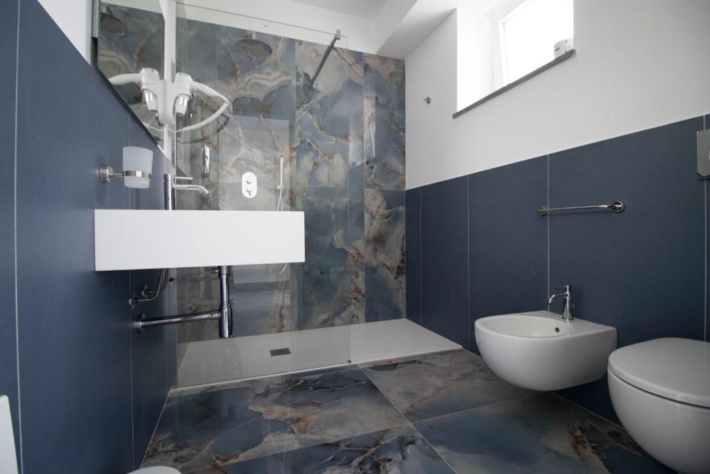 La salle de bains est pourvue de toilettes, d'un bidet et d'un lavabo. dans l'établissement Hotel Arte Mare, à San Vito Lo Capo