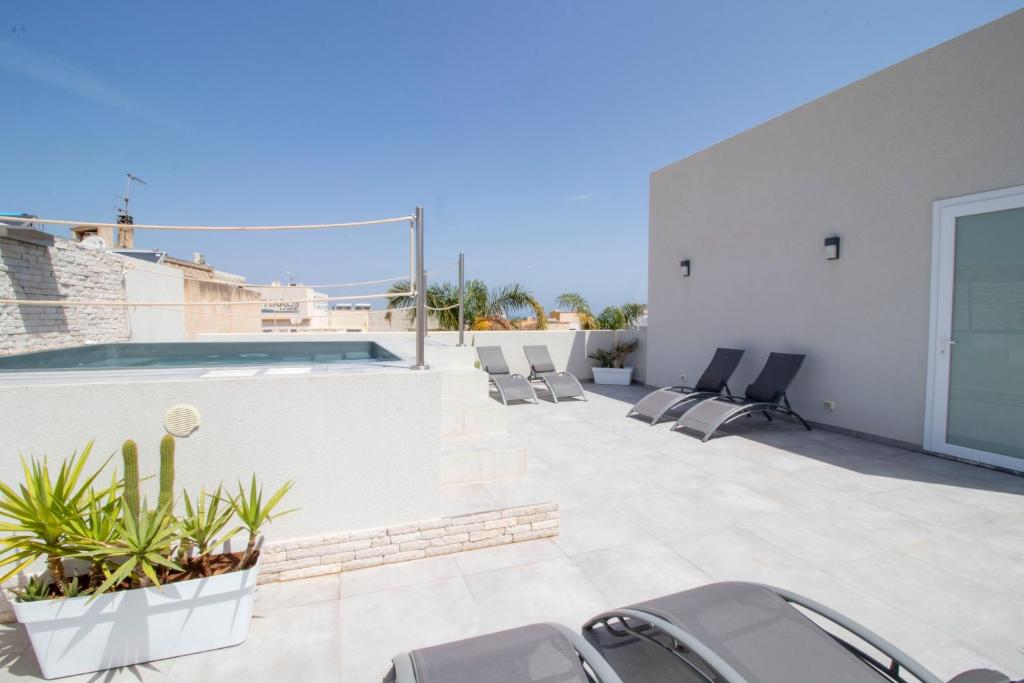 un patio avec des chaises et une piscine dans un bâtiment dans l'établissement Hotel Arte Mare, à San Vito Lo Capo