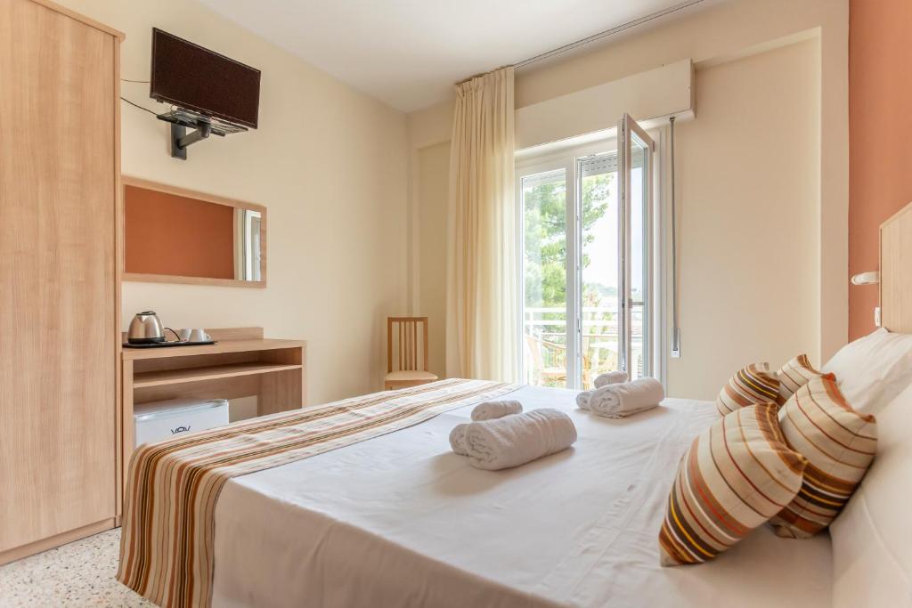 une chambre avec un grand lit avec des serviettes dessus dans l'établissement Hotel Cormoran Riccione, à Riccione 66 autres photos