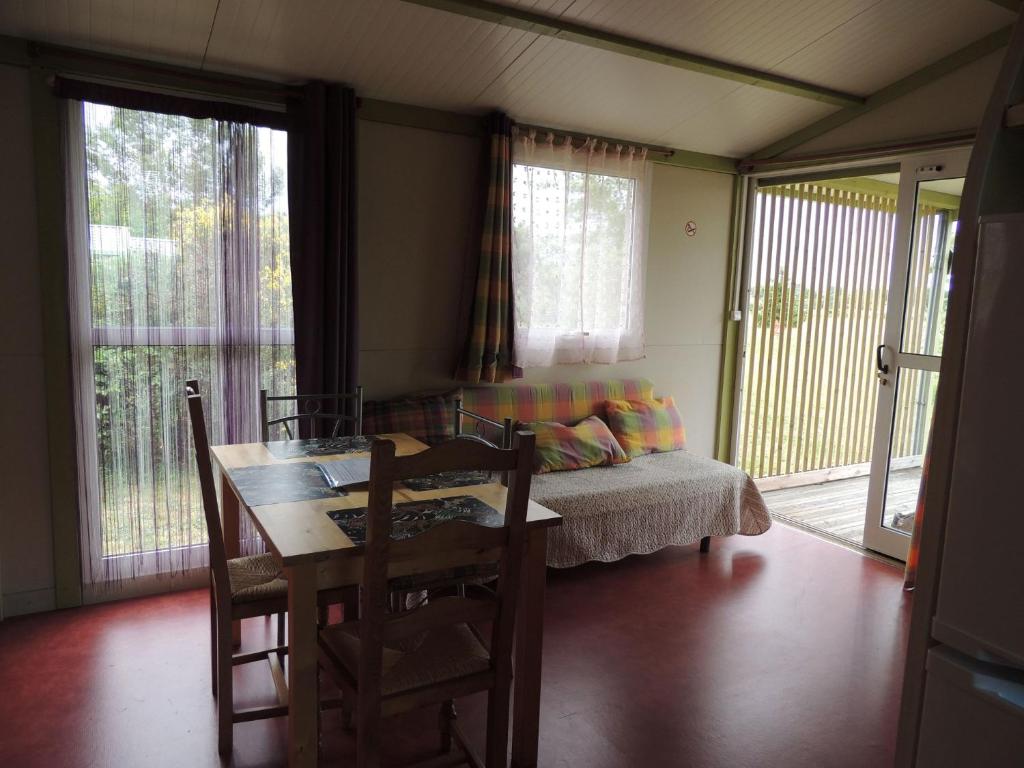 Cette chambre dispose d'une table, d'un lit et de fenêtres. dans l'établissement CHALET 4 personnes maxi tout confort location en gîte, à Chazemais