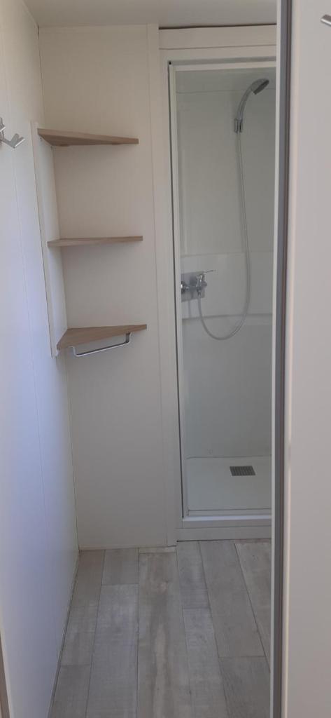 La salle de bains est pourvue d'une douche et d'un dressing. dans l'établissement Ecrins Santé, à Valras-Plage
