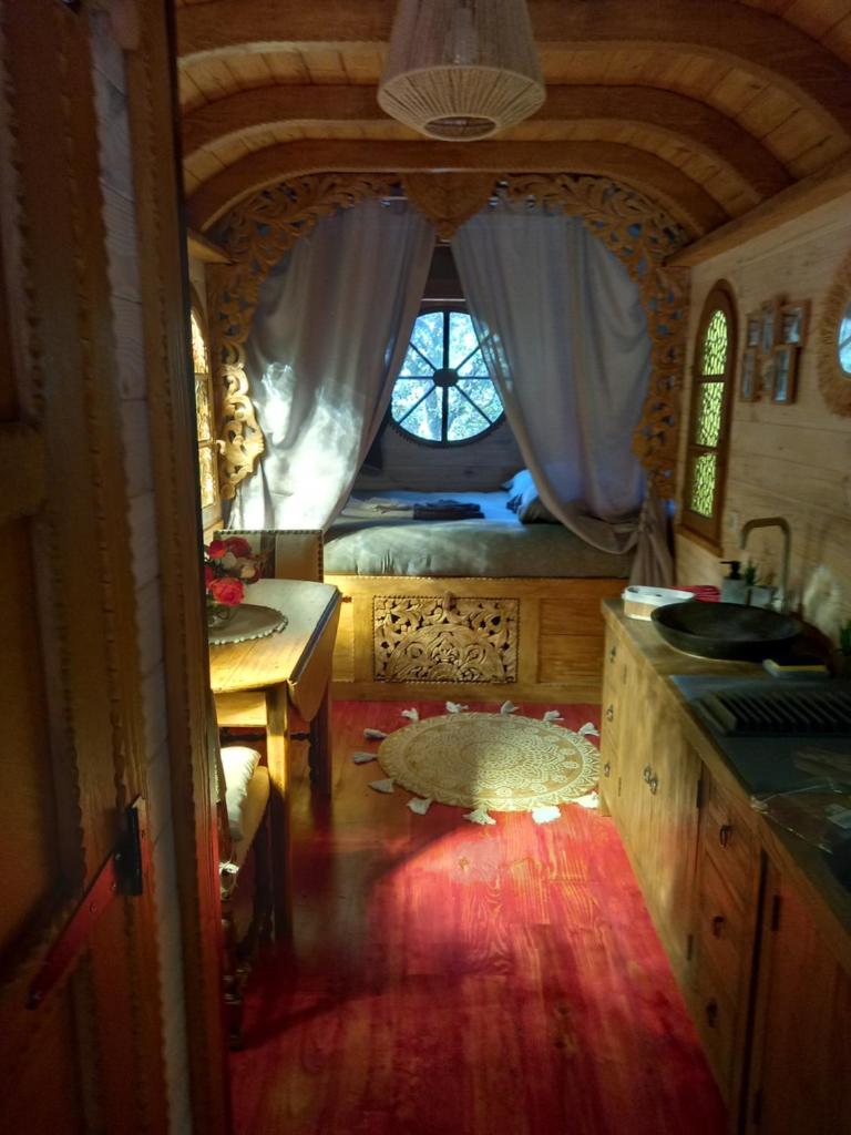 une chambre avec un lit, un lavabo et une fenêtre dans l'établissement La roulotte du petit paradis, à Saint-Rémy-de-Provence