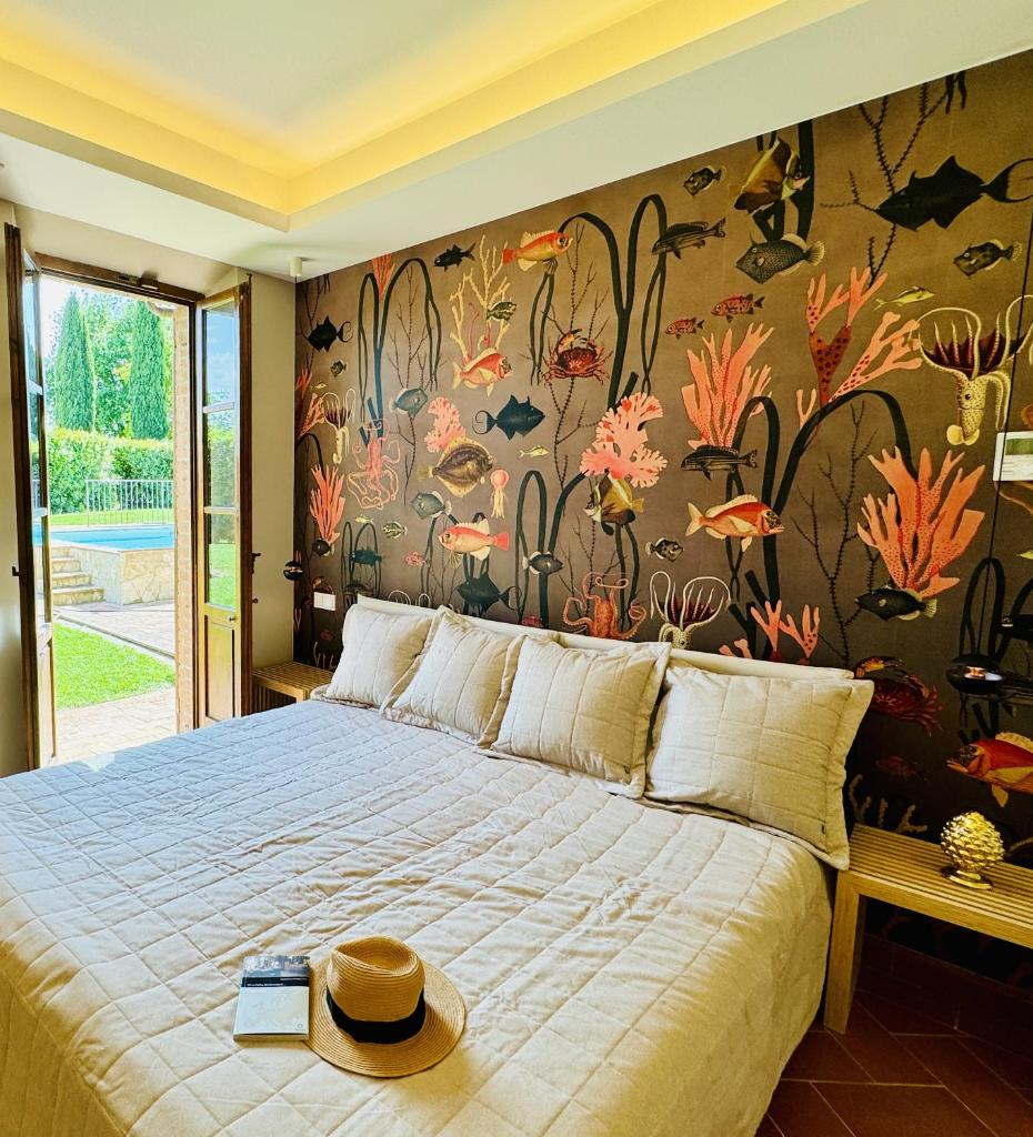 - une chambre avec un grand lit et un mur fleuri dans l'établissement Libertas Tuscan Hideaway, à San Sano