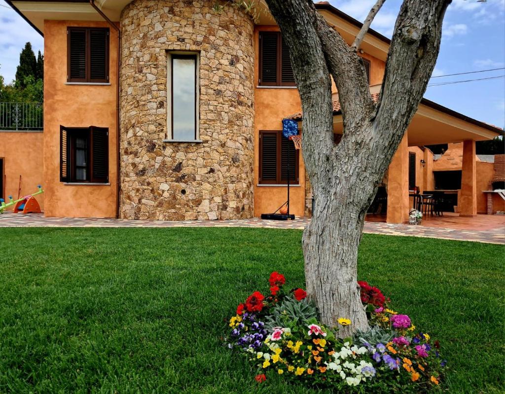 un arbre avec des fleurs devant une maison dans l'établissement Villa Ginevra, à San Pasquale
