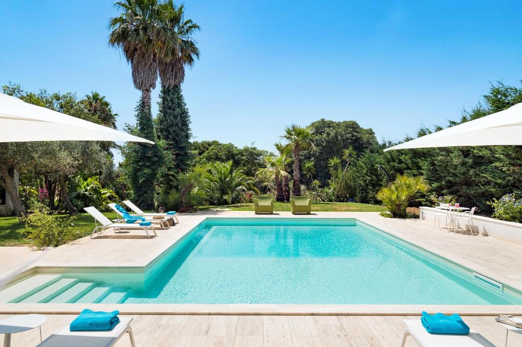 une piscine avec chaises et parasols dans l'établissement San Ciro, à Ulmi