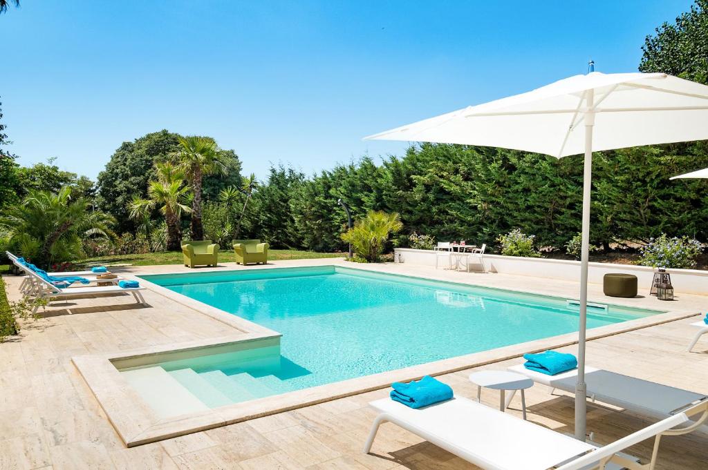 - une piscine avec un parasol, 2 chaises longues et un parasol dans l'établissement San Ciro, à Ulmi 35 autres photos