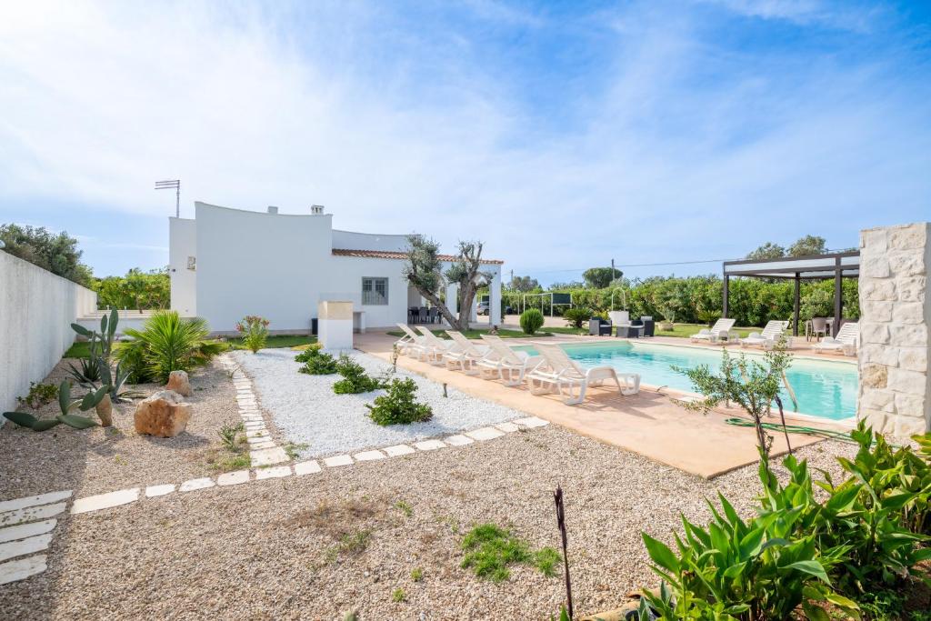 une cour arrière avec une piscine et une maison dans l'établissement Villa Città Bianca, à Carovigno