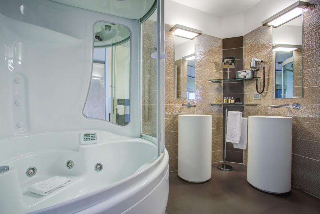 une salle de bain avec une baignoire blanche et une douche dans l'établissement Hotel Premier & Suites - Premier Resort, à Milano Marittima