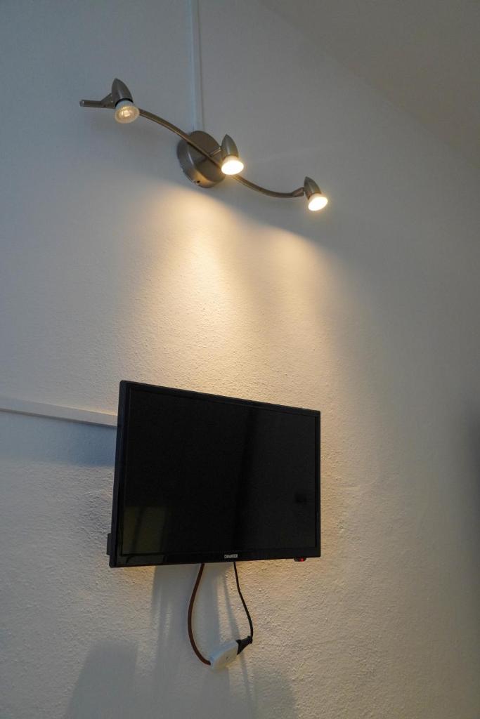 un téléviseur à écran plat accroché au mur dans l'établissement Hotel Cilene, à Viareggio