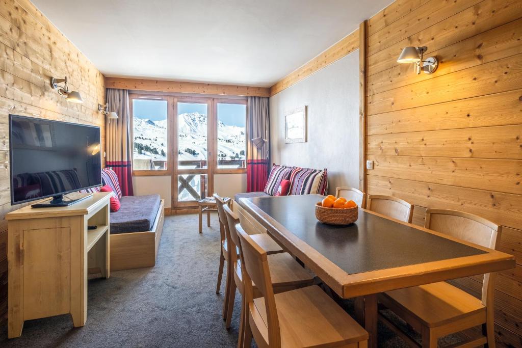 un salon avec une table de salle à manger et une cuisine dans l'établissement Résidence Pierre & Vacances Les Néréides, à Belle Plagne