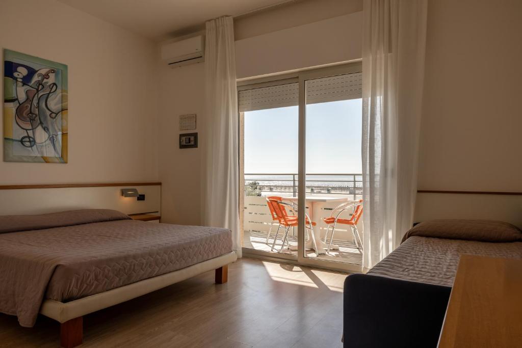 une chambre avec deux lits et un balcon avec vue dans l'établissement Hotel Continental, à Caorle