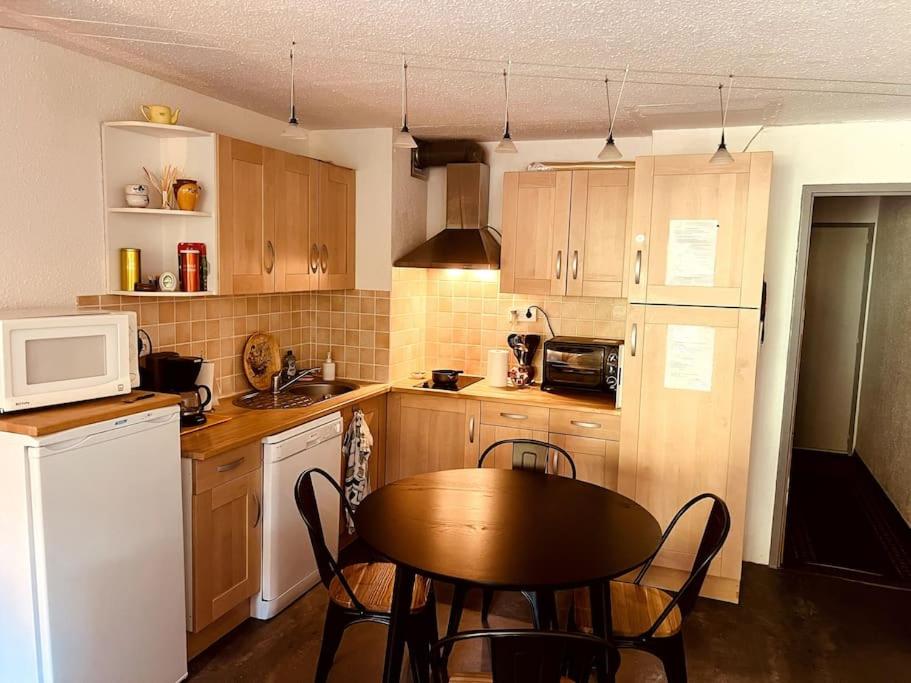 une petite cuisine avec une table et un micro-ondes dans l'établissement Studio Peyragudes pied des pistes 4/5 pers Les Agudes, à Gouaux-de-Larboust