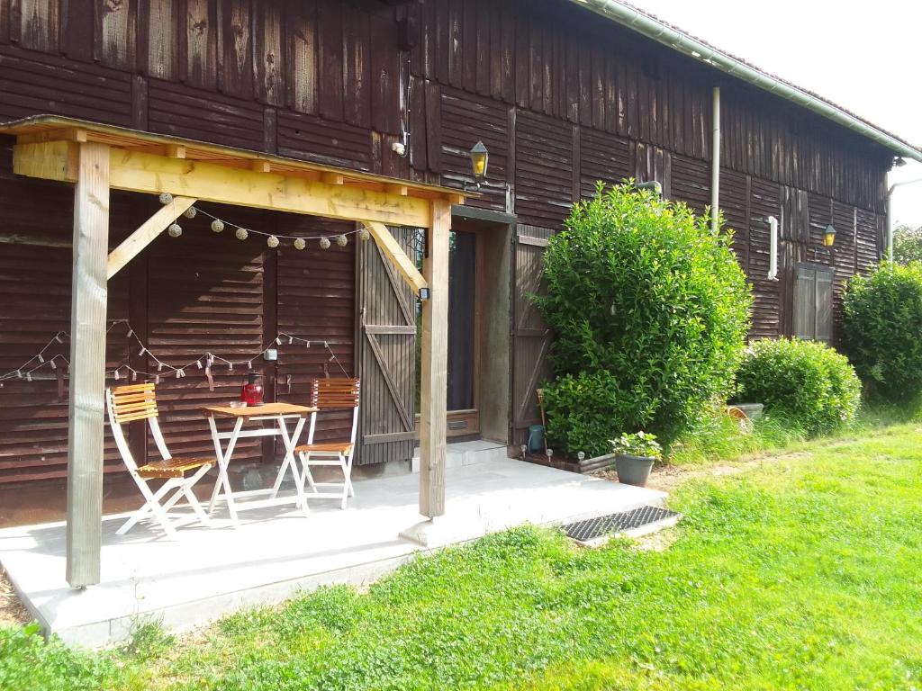 un patio avec une table et des chaises devant une maison dans l'établissement Maison des Soupirs, à Montpon-Ménestérol