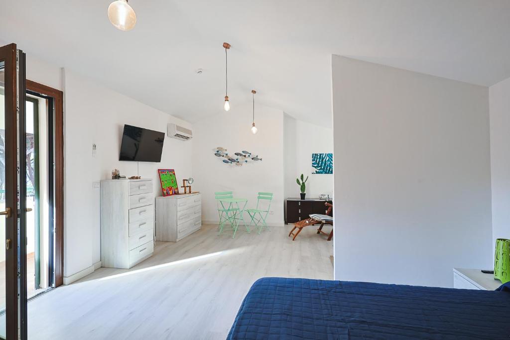 une chambre blanche avec un lit bleu et un bureau dans l'établissement Pineta Azzurra, à Marina di Grosseto