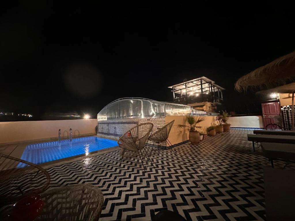 - une piscine entourée de chaises la nuit dans l'établissement Riad Dar Tahri & SPA, à Fès