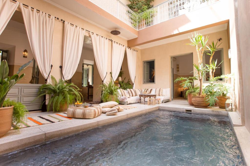 une piscine au milieu d'une maison avec des plantes dans l'établissement Riad Olema et Spa, à Marrakech