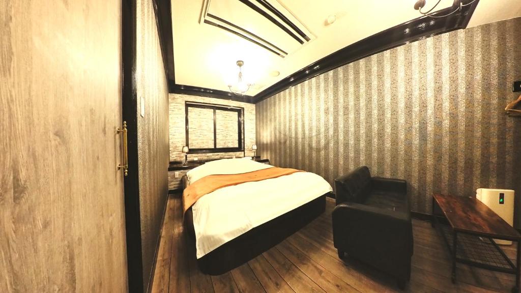 une chambre avec un lit, un bureau et une fenêtre dans l'établissement アンブレイン堺, à Sakai