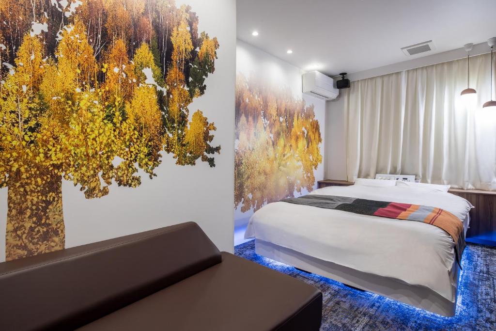 - une chambre avec un lit et une fresque murale sur les arbres dans l'établissement HOTEL MONO - Adult only, à Ueda