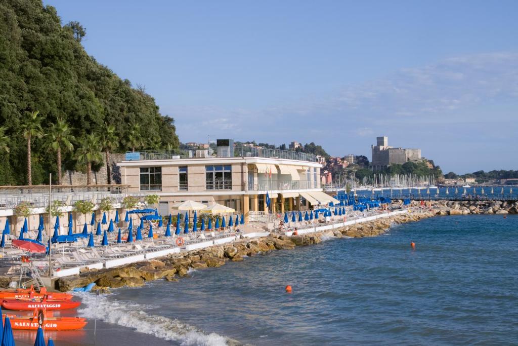 un groupe de chaises et de parasols sur une plage dans l'établissement Hotel San Terenzo, à Lerici