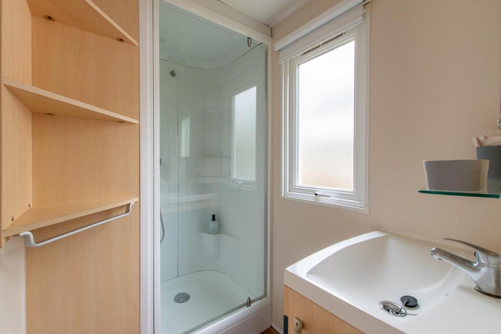une salle de bain avec douche et lavabo dans l'établissement Mobil-home Entre Terre & Mer, à Agde
