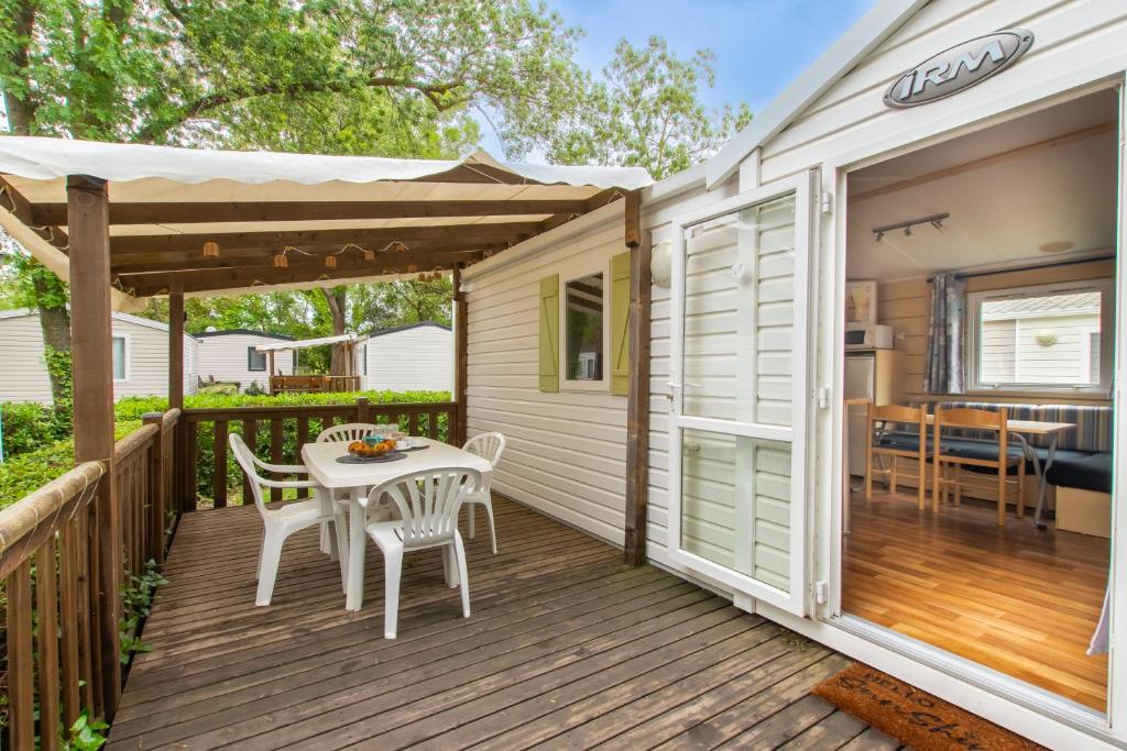 un patio avec une table et des chaises sur une terrasse dans l'établissement Mobil-home Entre Terre & Mer, à Agde