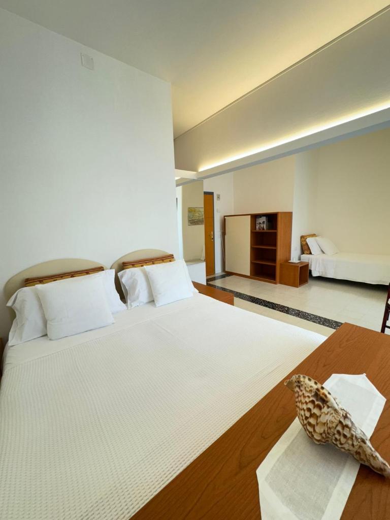 - une chambre avec un grand lit blanc et une table dans l'établissement Hotel Pinocchio, à Cattolica 66 autres photos