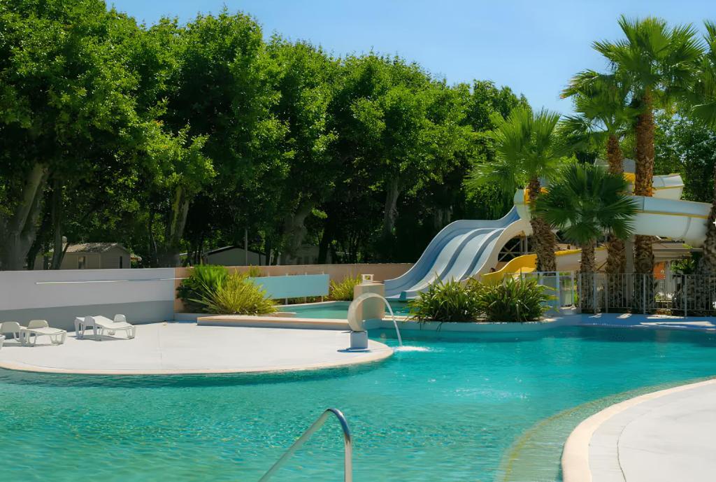 - une piscine avec toboggan dans un complexe dans l'établissement Mobil home 6 personnes confort Océan climatisé camping avec piscine Agde, à Agde