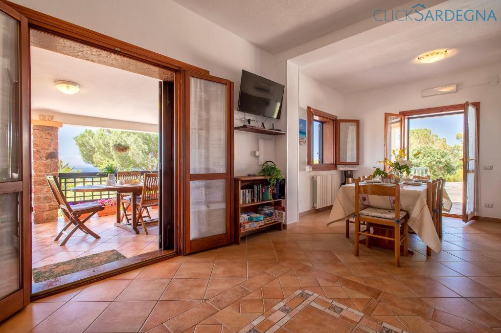 un salon avec une table et une salle à manger dans l'établissement Alghero Villa Barranch with sea view swimming pool for 6 people, à Alghero