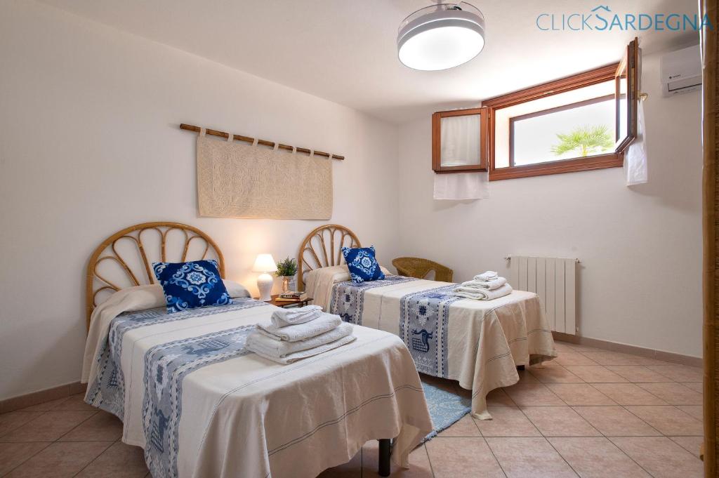une chambre avec deux lits et une fenêtre dans l'établissement Alghero Villa Barranch with sea view swimming pool for 6 people, à Alghero 151 autres photos