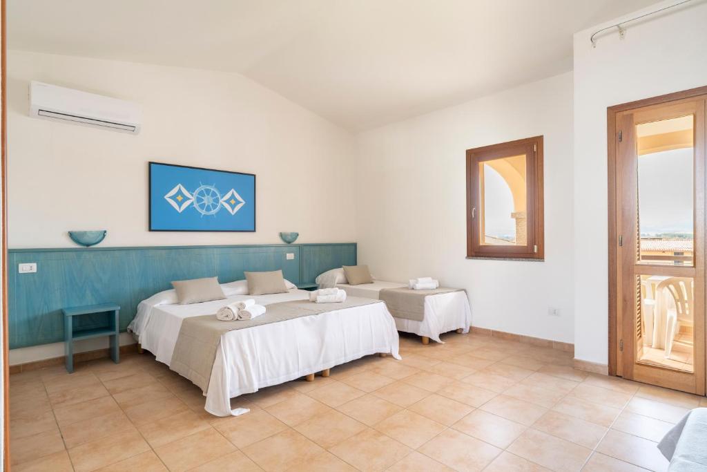 une chambre avec deux lits et une fenêtre dans l'établissement Mimose Beach Village, à Badesi