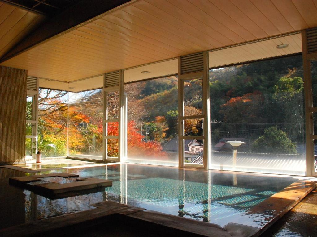 une maison avec une piscine et une grande fenêtre dans l'établissement Sakaya Ryokan Yoshina Onsen, à Izu
