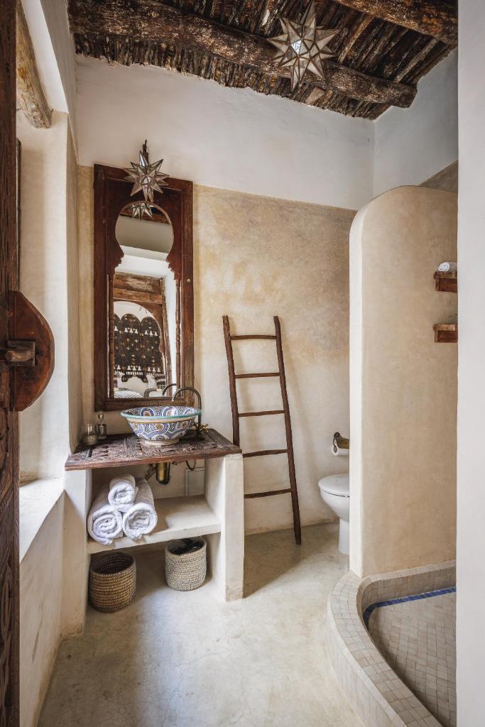 une salle de bain avec un lavabo, des toilettes et un miroir dans l'établissement Riad Alkemia en exclusivité, à Marrakech