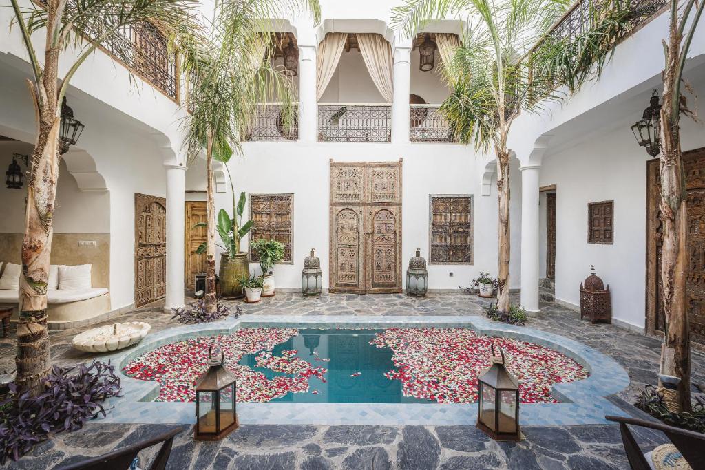 une piscine intérieure avec des palmiers dans un bâtiment dans l'établissement Riad Alkemia en exclusivité, à Marrakech