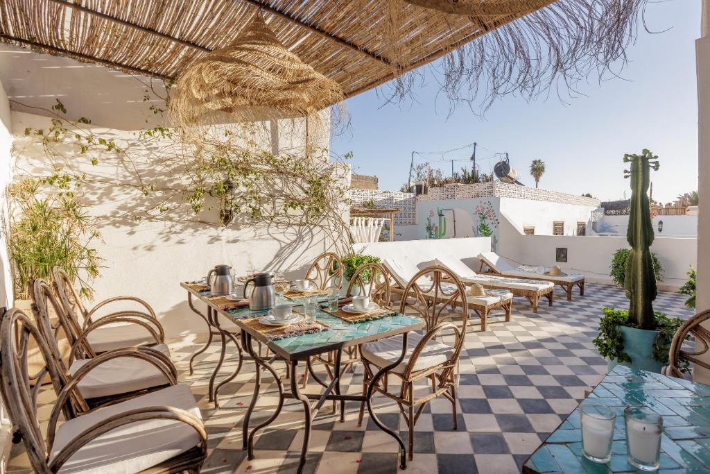 d'une terrasse sur le toit avec des tables et des chaises. dans l'établissement Riad Alkemia en exclusivité, à Marrakech