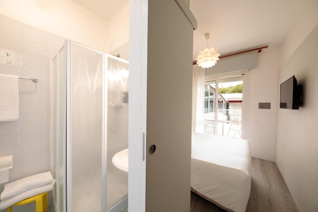 une salle de bain blanche avec lavabo et douche dans l'établissement Hotel Derby S, à Lido di Jesolo